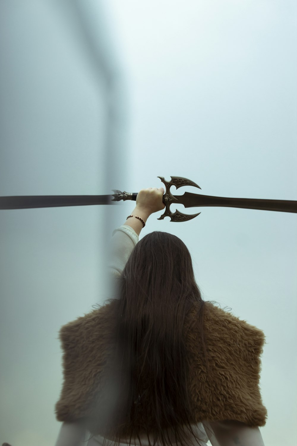 a woman holding a sword with a bird on it