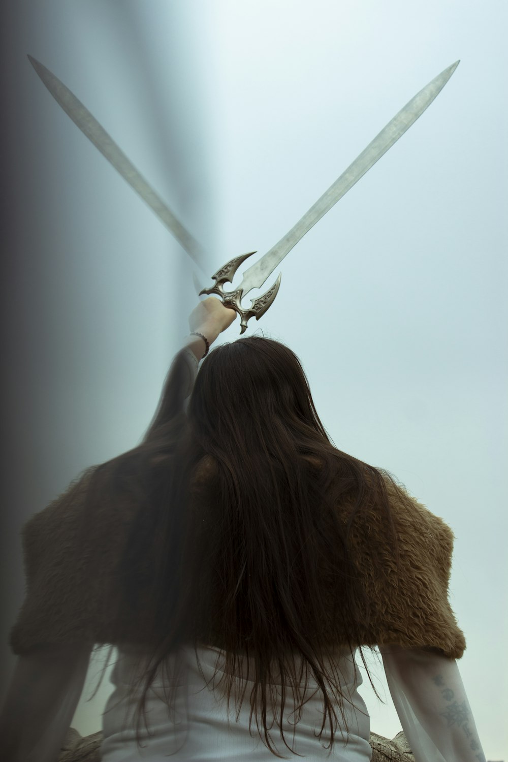 a woman holding two swords in her hands