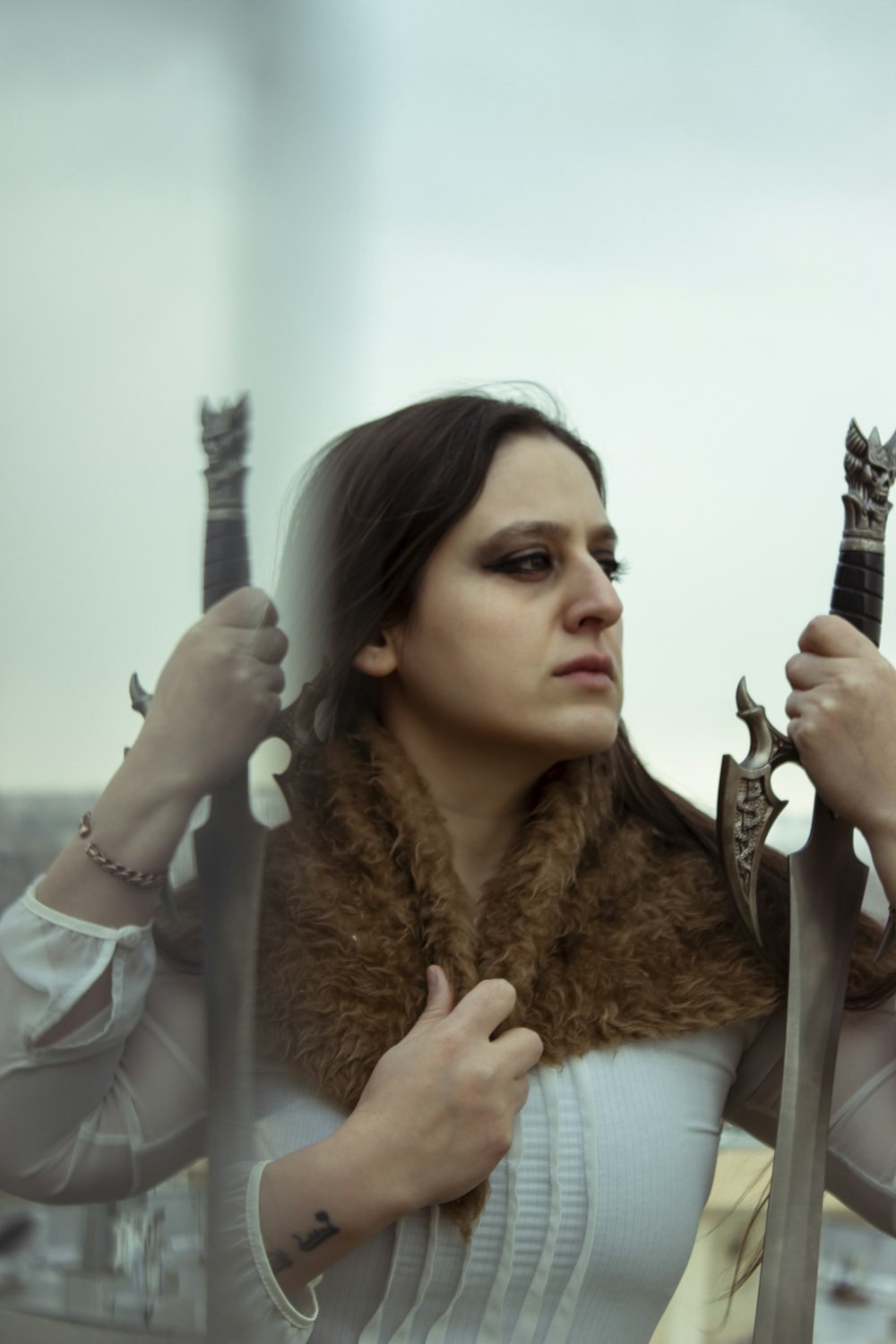 a woman holding two swords in her hands