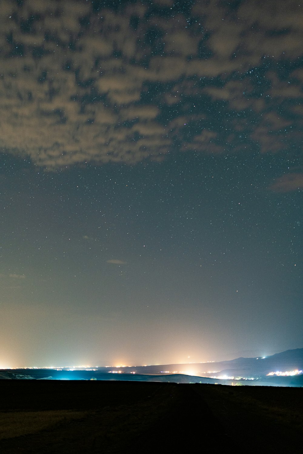 the night sky is lit up with stars and clouds