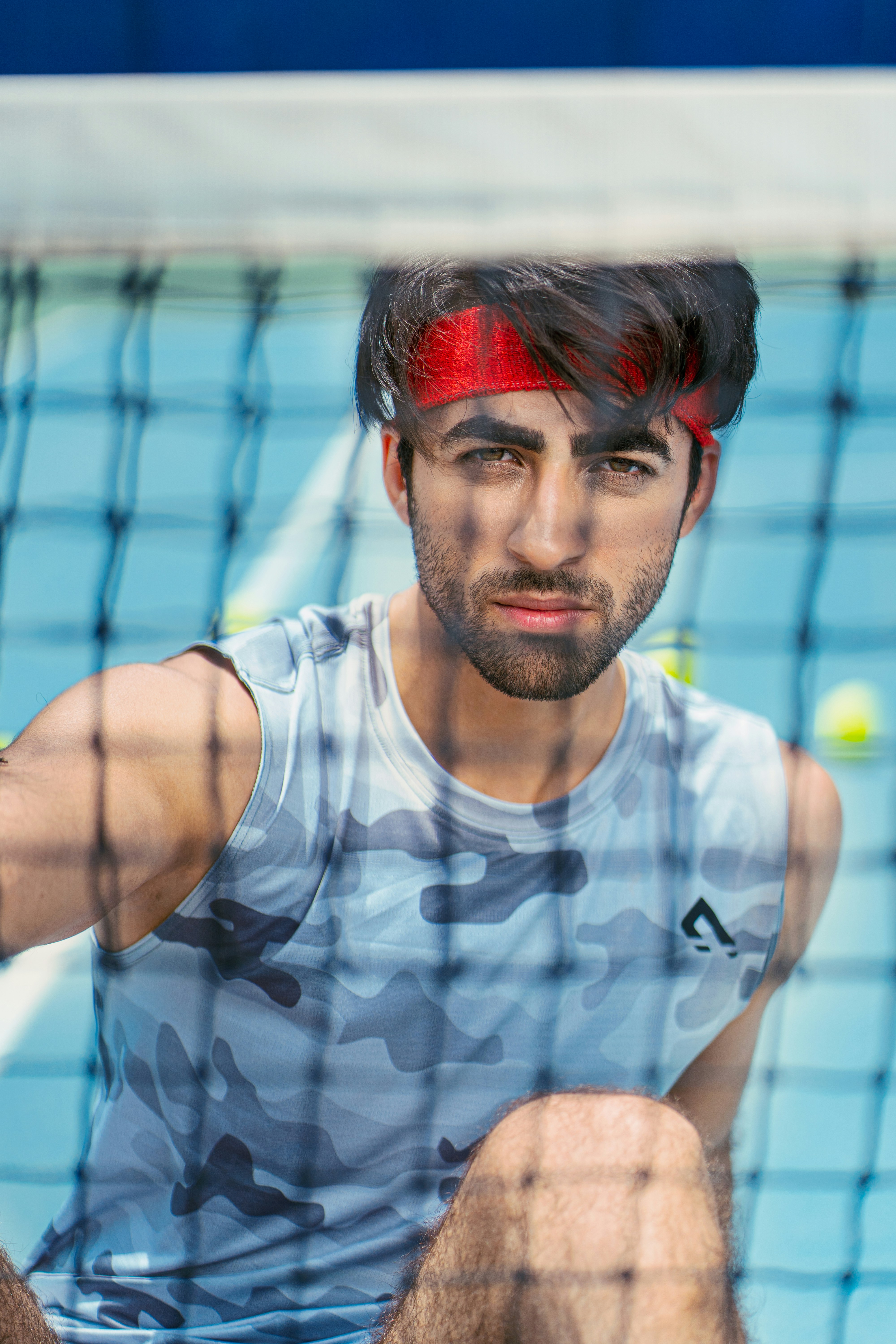 a man sitting on a tennis court holding a racquet