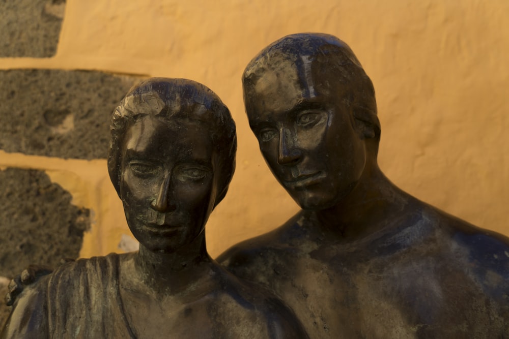 Una estatua de dos personas de pie una al lado de la otra
