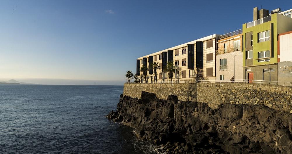 a row of multi - story buildings next to the ocean