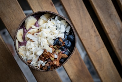 Close-up of a delicious açaí bowl topped with fresh fruits and granola on a wooden table.