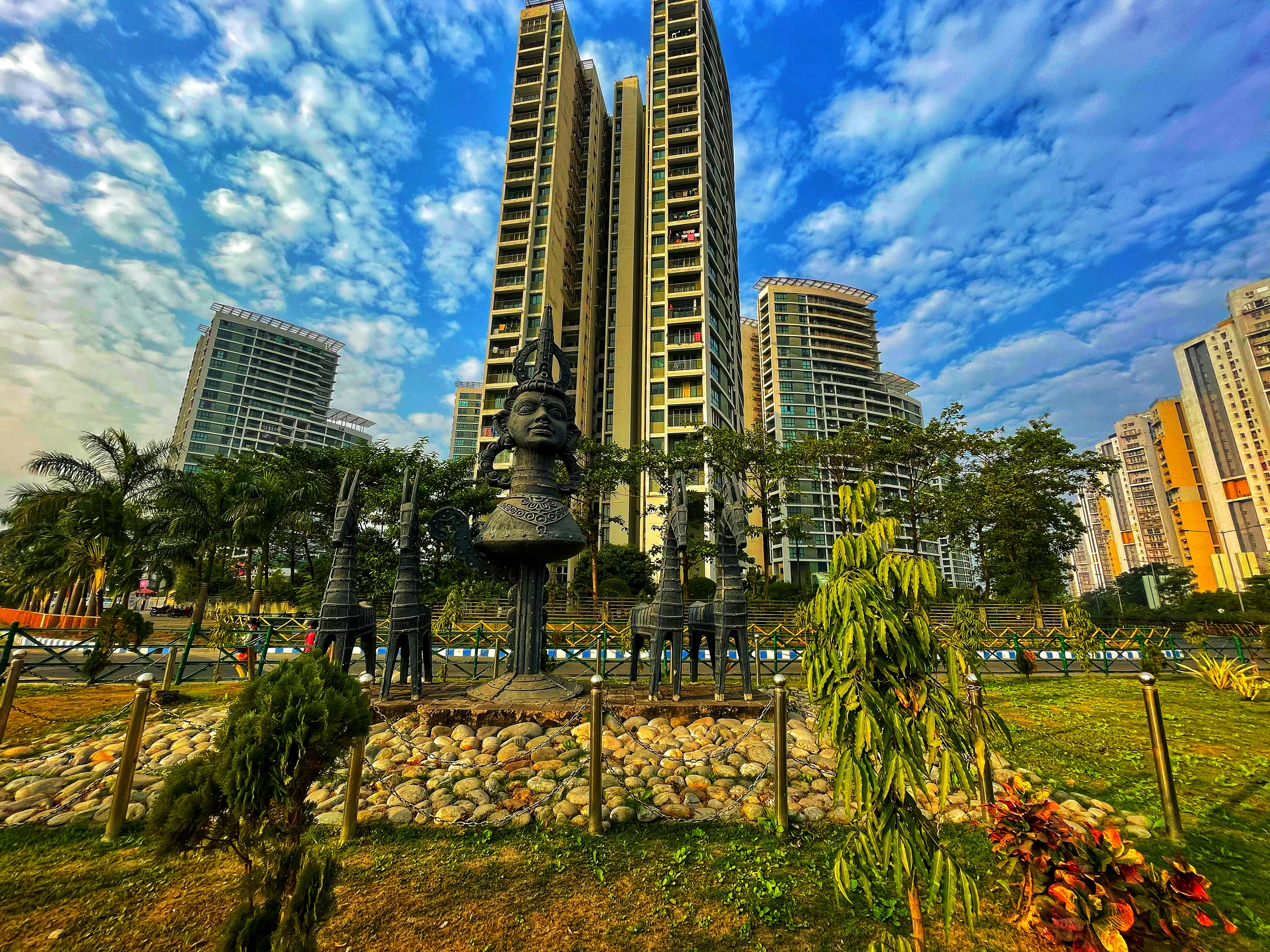 a very tall building sitting next to a lush green park