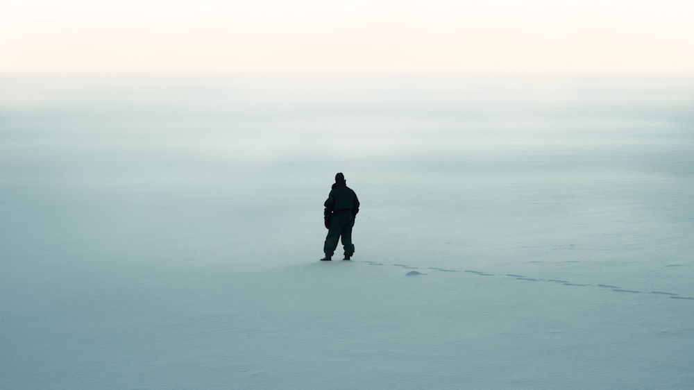 a person standing in the middle of a snowy field