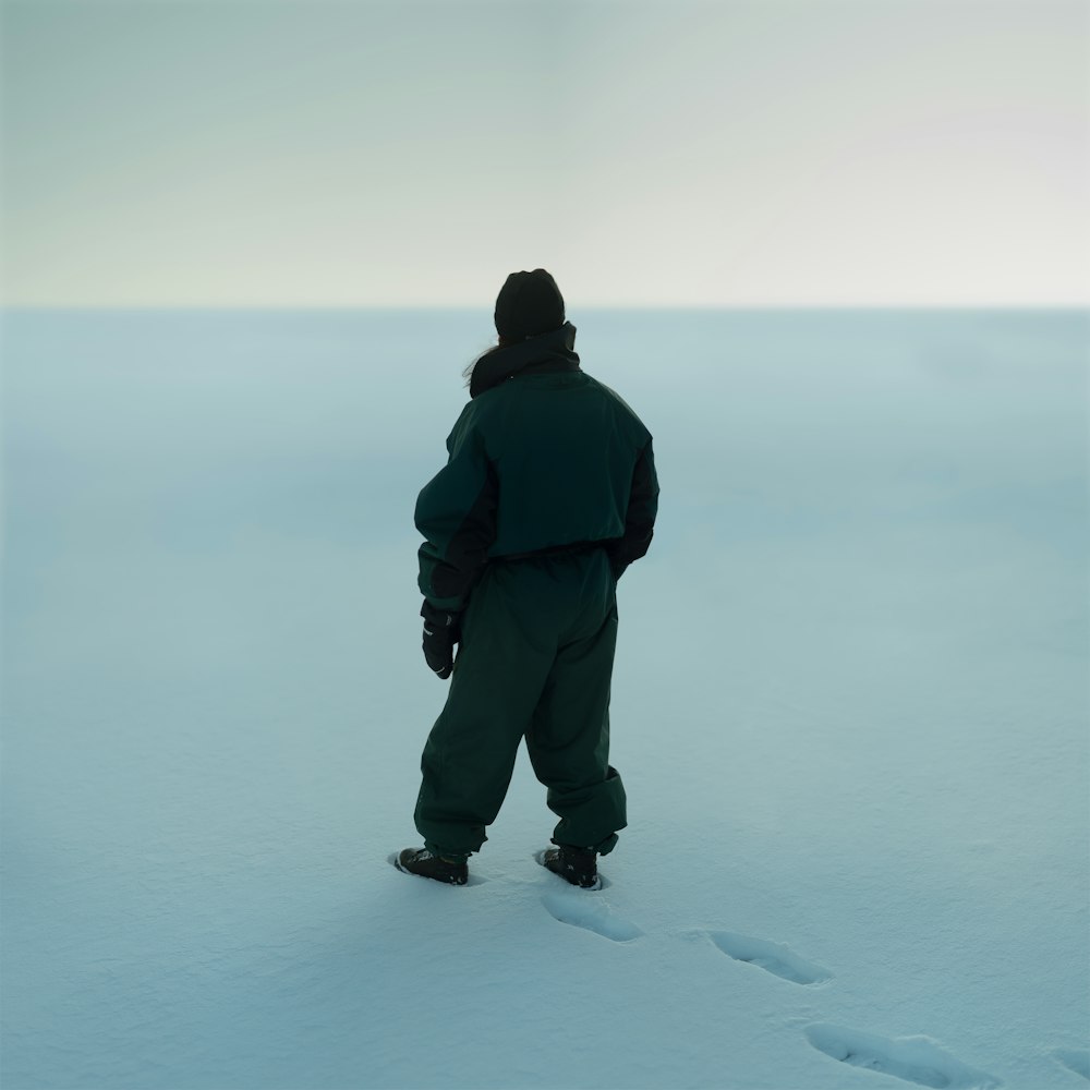 a man standing in the middle of a snow covered field
