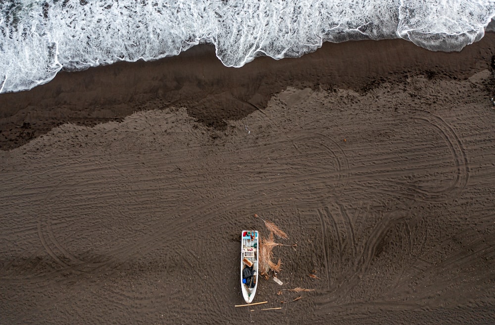 an aerial view of a boat on the beach