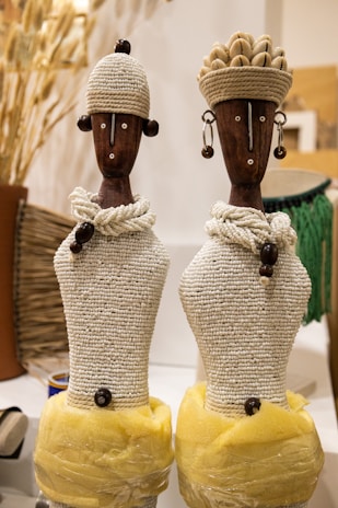 a couple of wooden statues sitting on top of a table