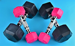 a pair of pink and black dumbs on a blue background