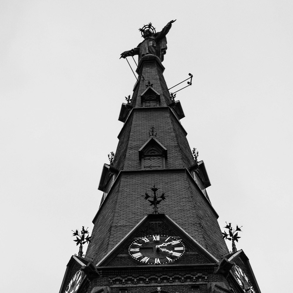 a clock tower with a statue on top of it