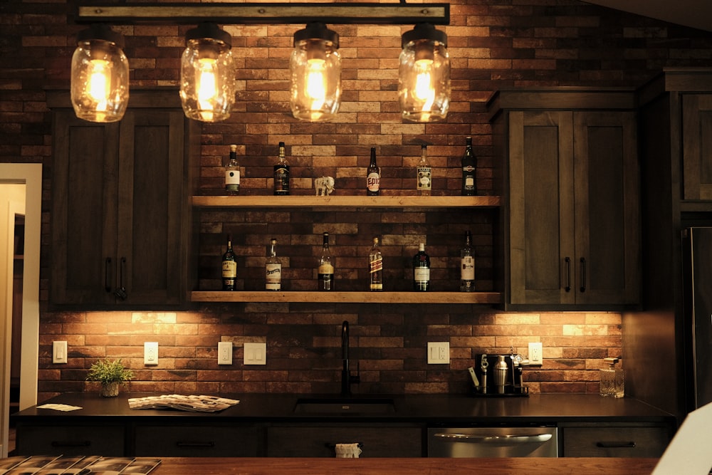 a kitchen with a brick wall and lights above it