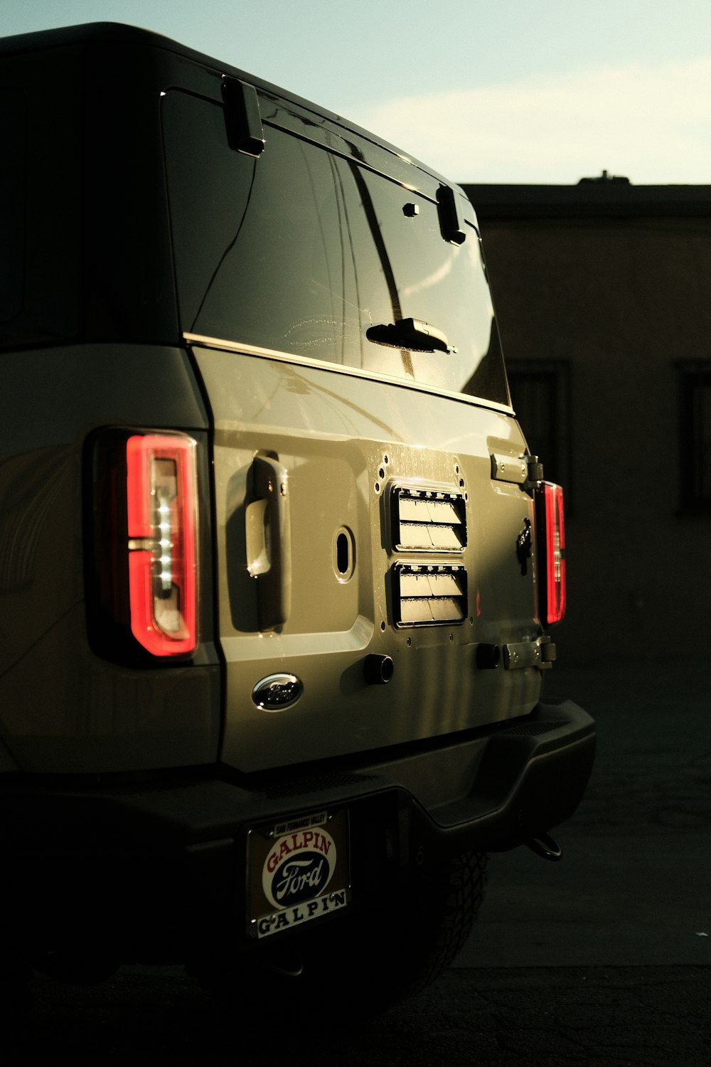 the tail lights of a black and tan truck