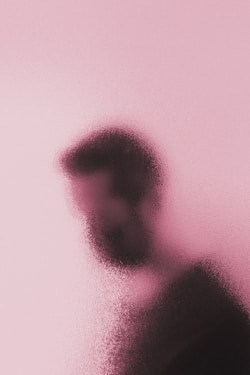a blurry image of a person's face on a pink background