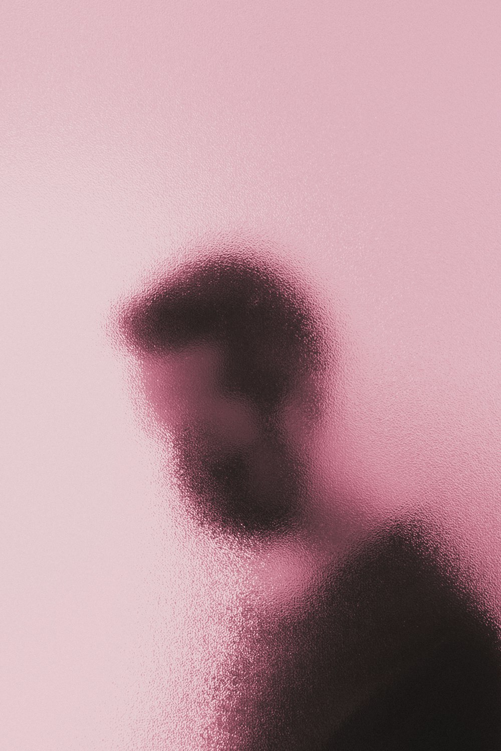 a blurry image of a person's face on a pink background