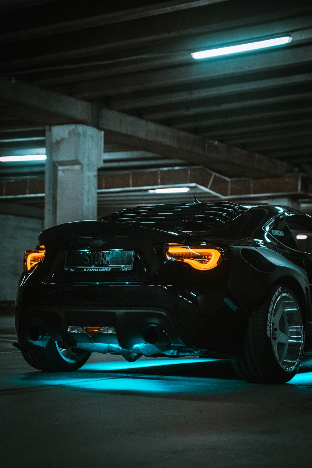 a black sports car parked in a parking garage