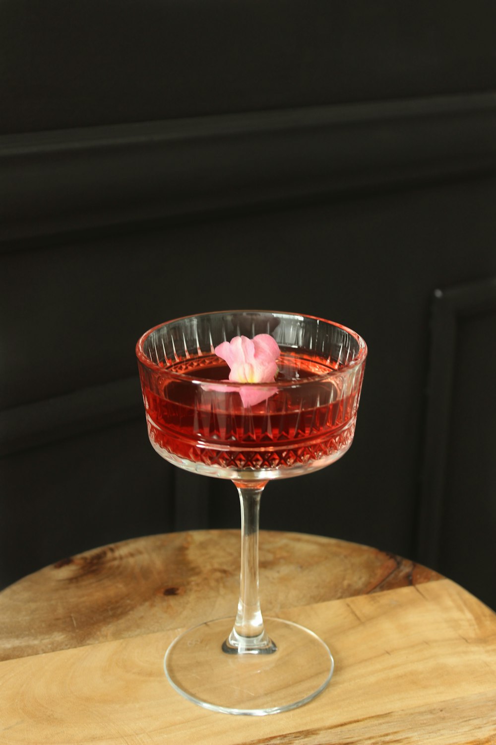 a wine glass with a pink flower in it