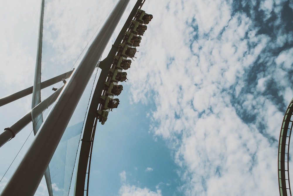 a roller coaster going through a cloudy blue sky