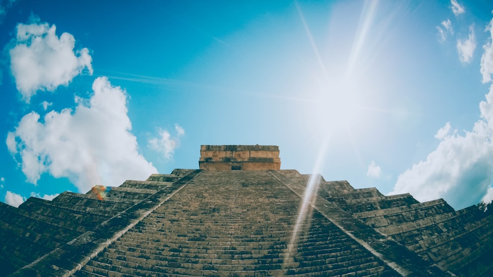 the sun shines brightly over a pyramid