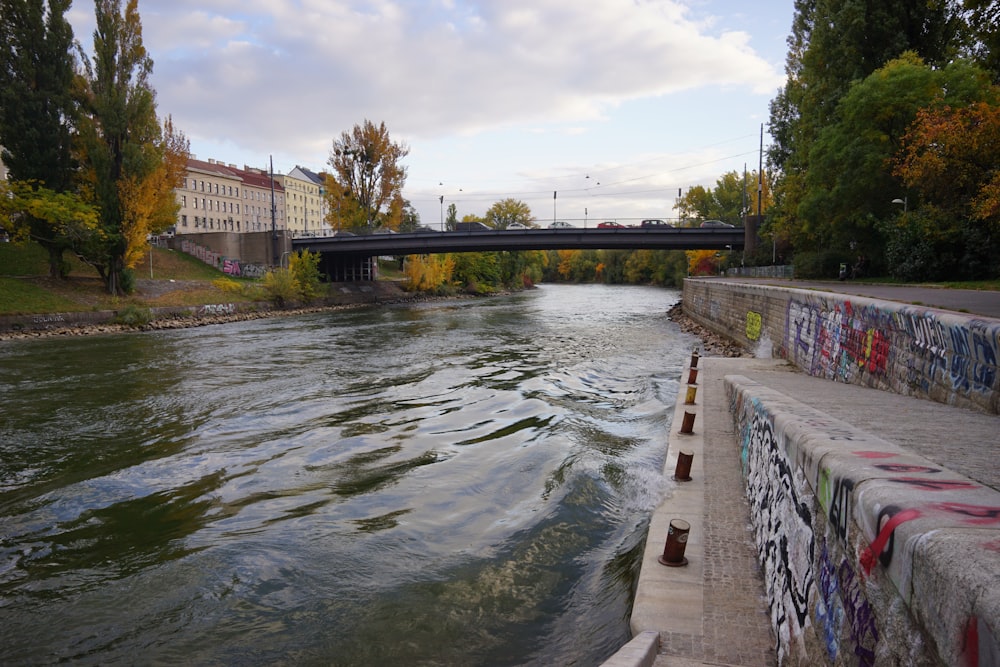 a bridge over a river with graffiti on it