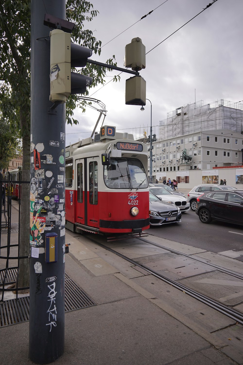 a red and white trolley on a city street
