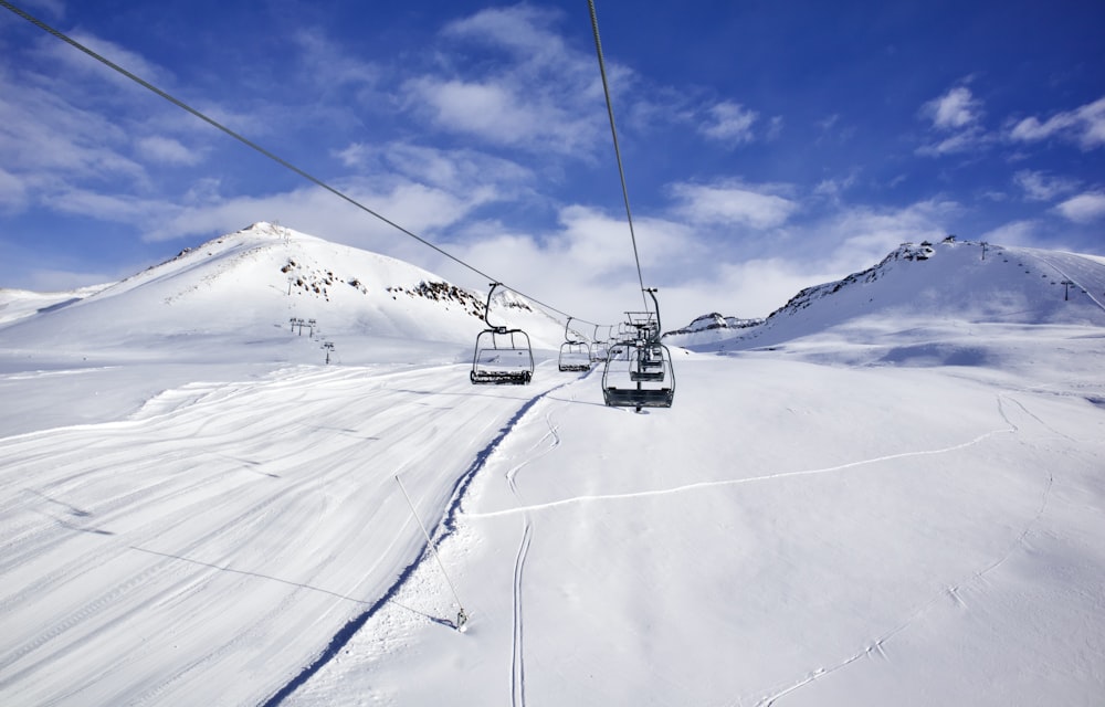 a ski lift going up the side of a snow covered mountain