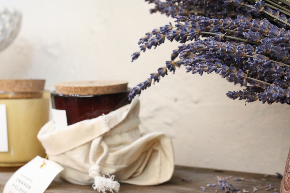 a jar of honey and some lavender flowers on a table