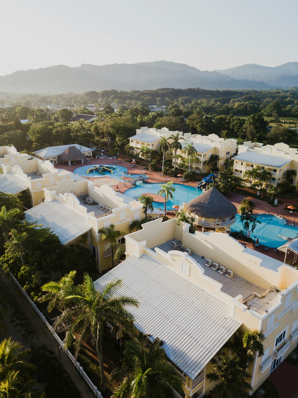 an aerial view of a resort surrounded by palm trees