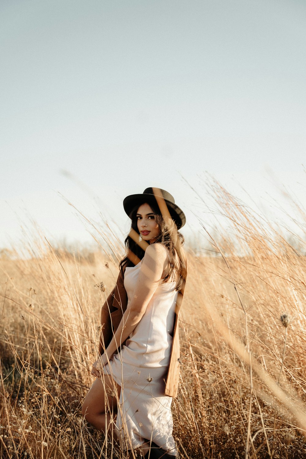 a woman standing in a field of tall grass