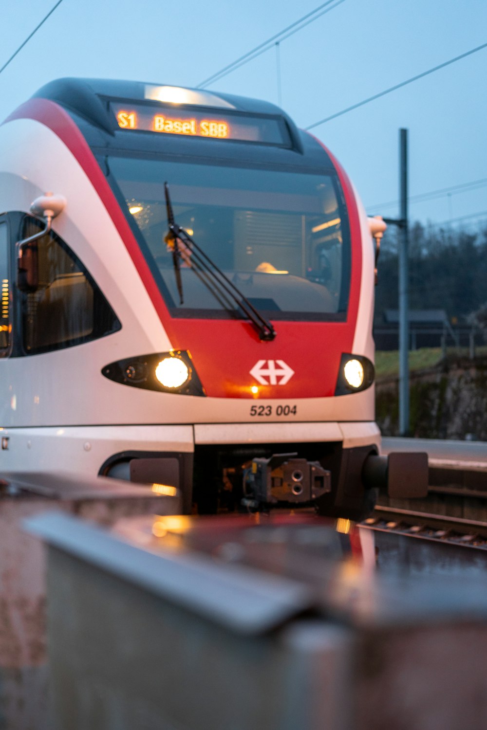 a red and white train traveling down train tracks