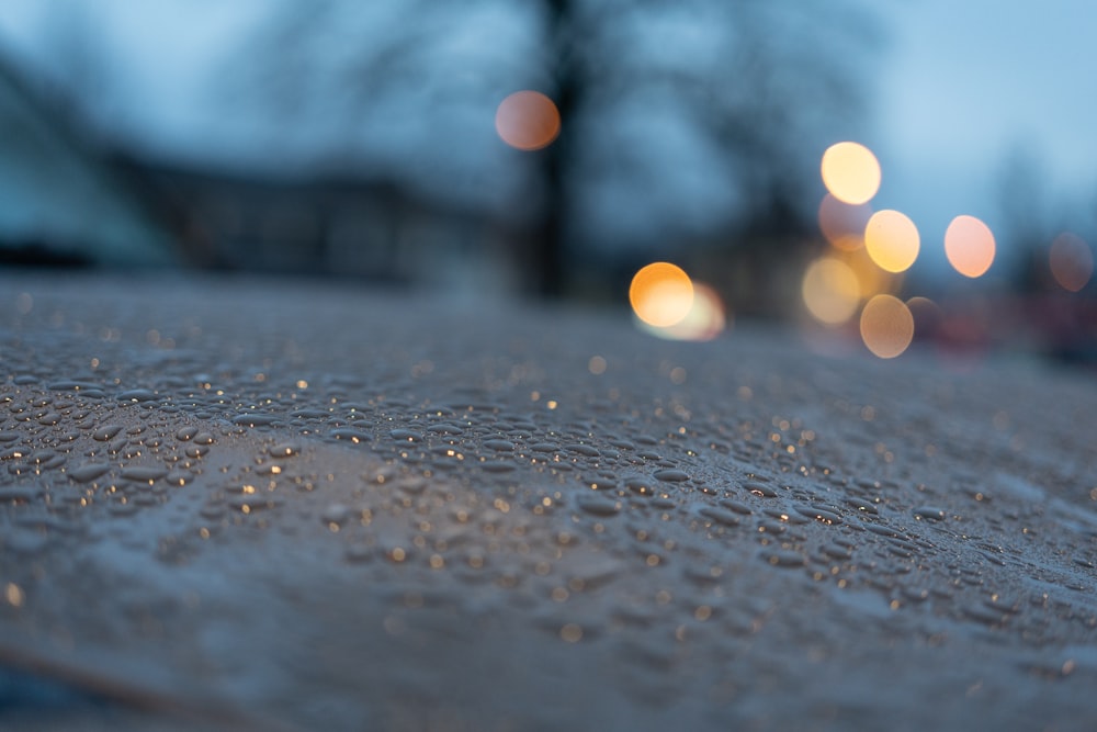 a close up of a wet surface with blurry lights in the background