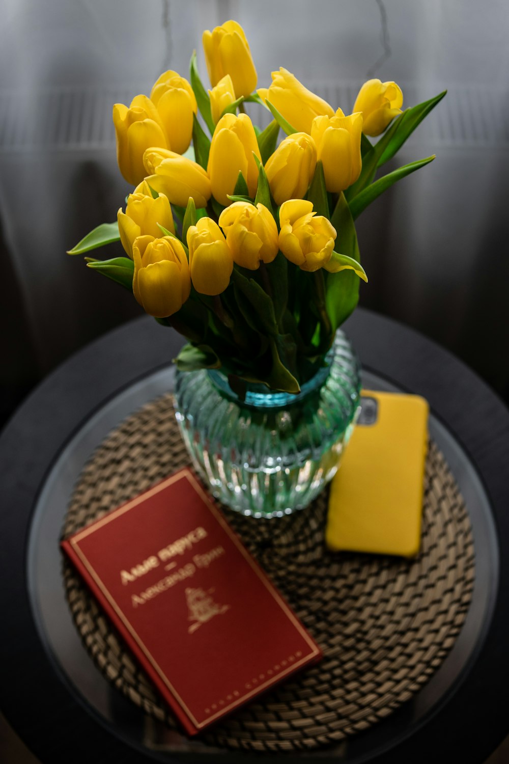 a vase of yellow tulips on a table