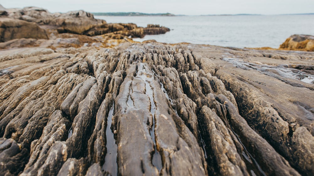 a close up of a rock formation near a body of water