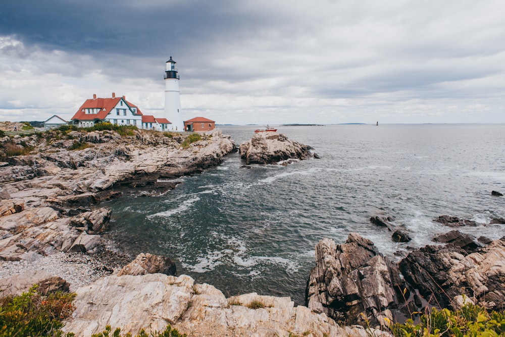 a light house sitting on top of a cliff next to the ocean