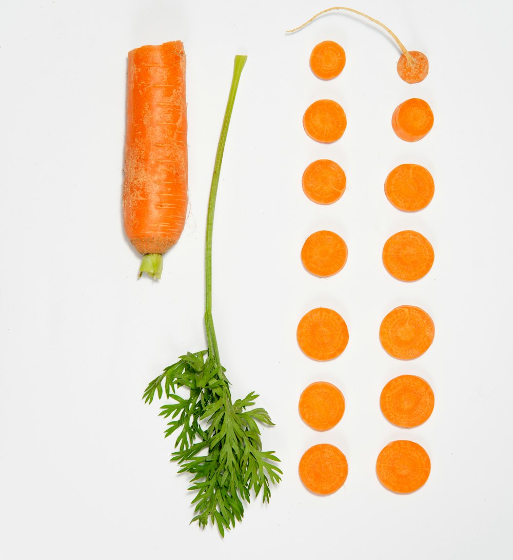 a carrot and a bunch of carrots on a white surface