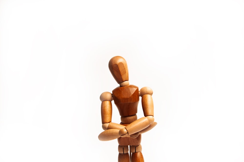 a wooden toy sitting on top of a white surface