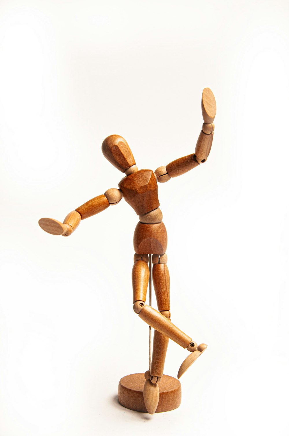 a wooden toy standing on a white surface