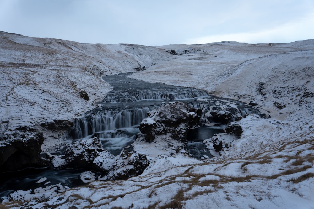 a frozen waterfall in the middle of a snowy landscape