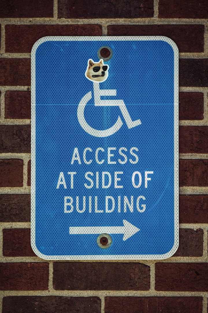 Access at side of the building sign on a brick background. Designed to point out the assistance with ndis navigation provided by strategic self-advocacy