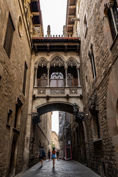 a couple of people that are walking under a bridge