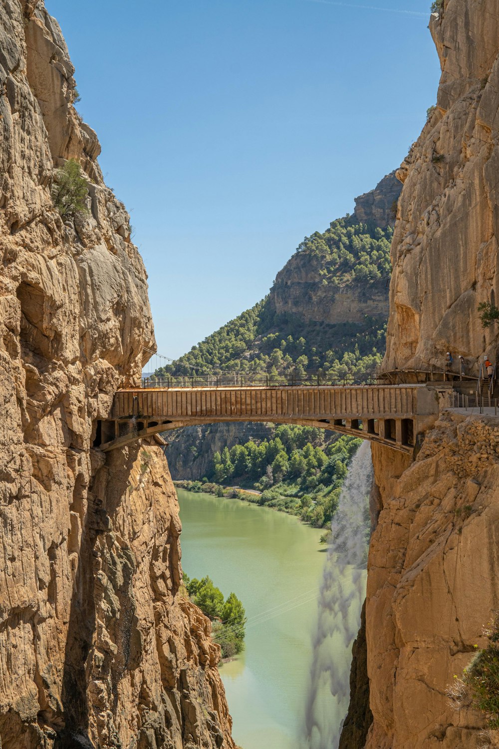 a bridge over a river between two mountains