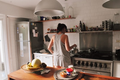 a woman standing in a kitchen next to a stove top oven