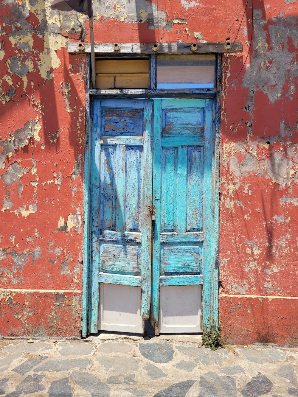 Una puerta azul está abierta en una pared roja