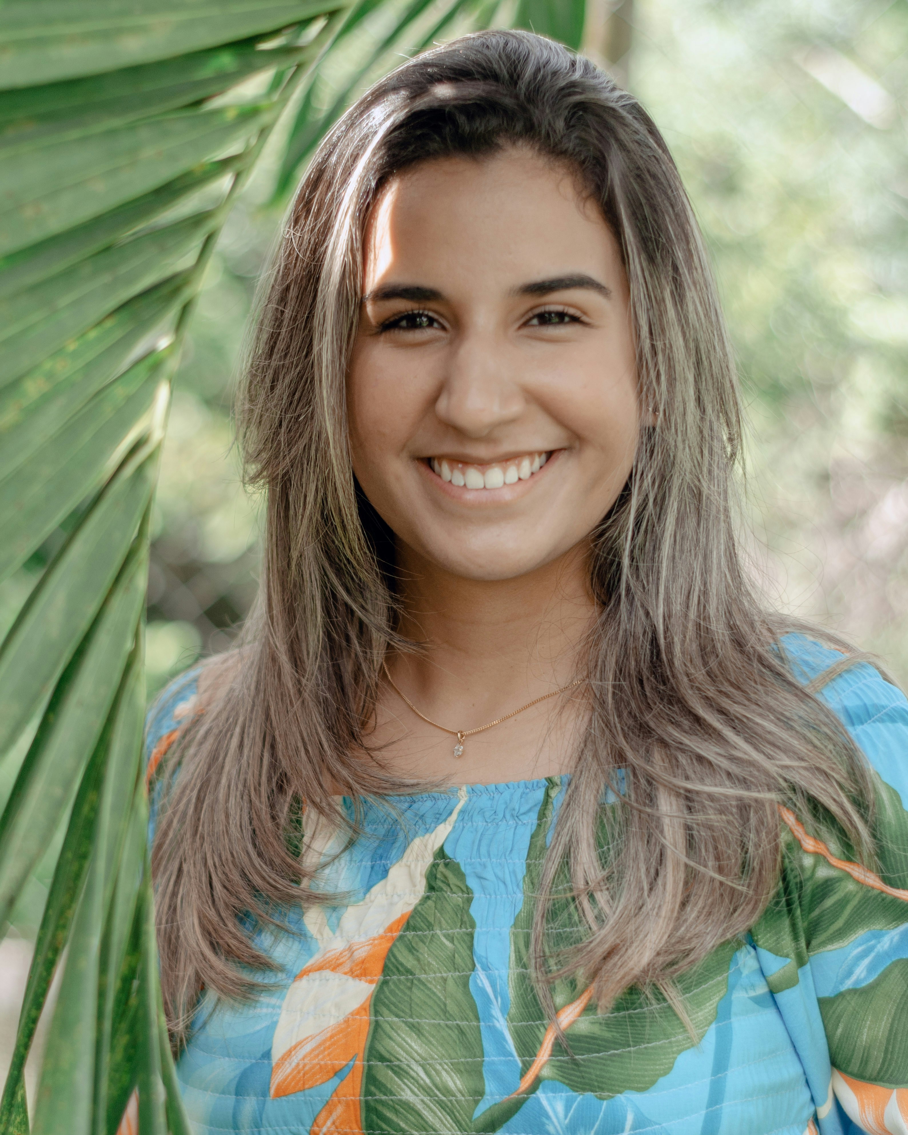 a woman with long gray hair smiling at the camera