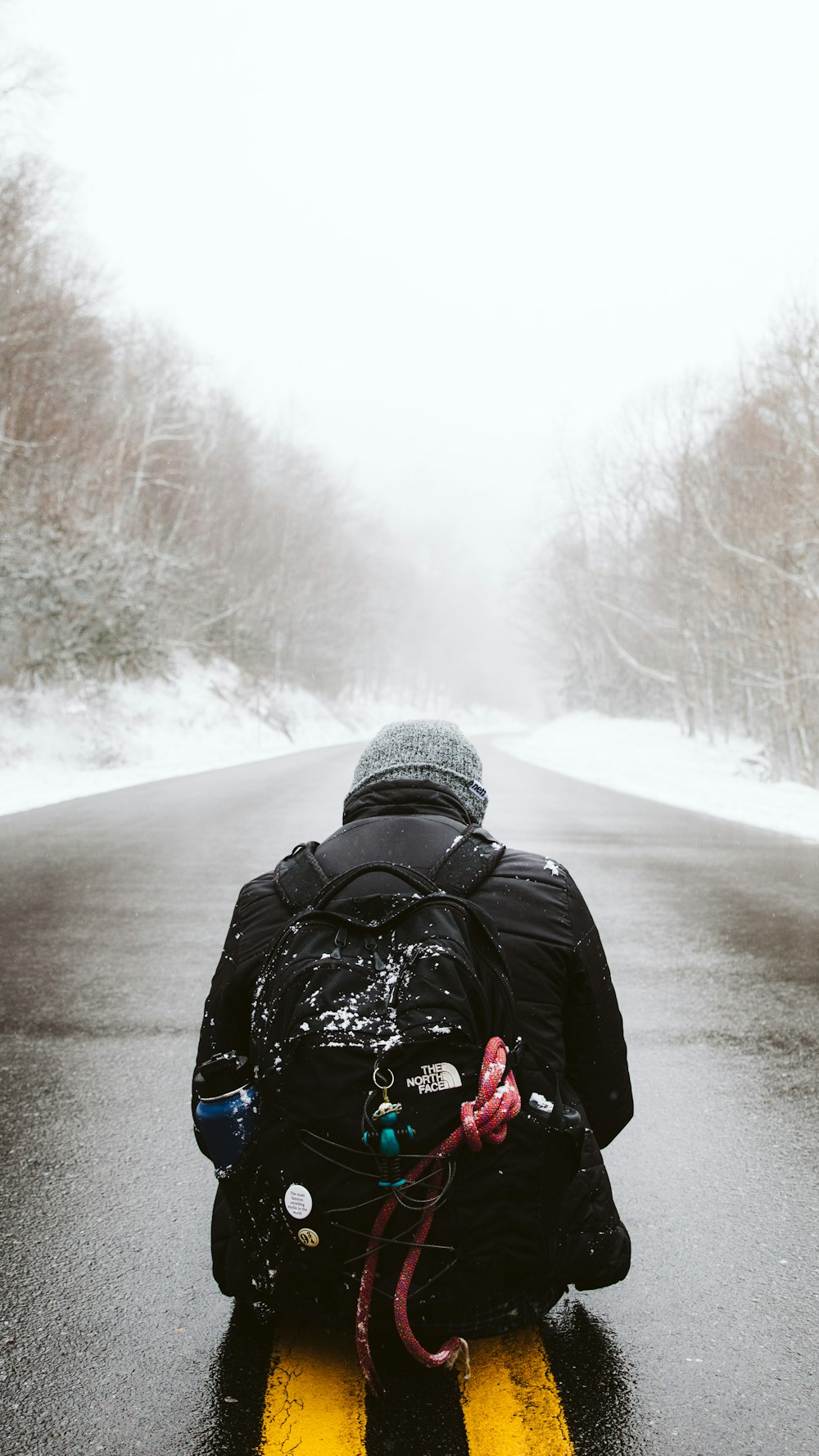 a man riding a snowmobile down a snow covered road