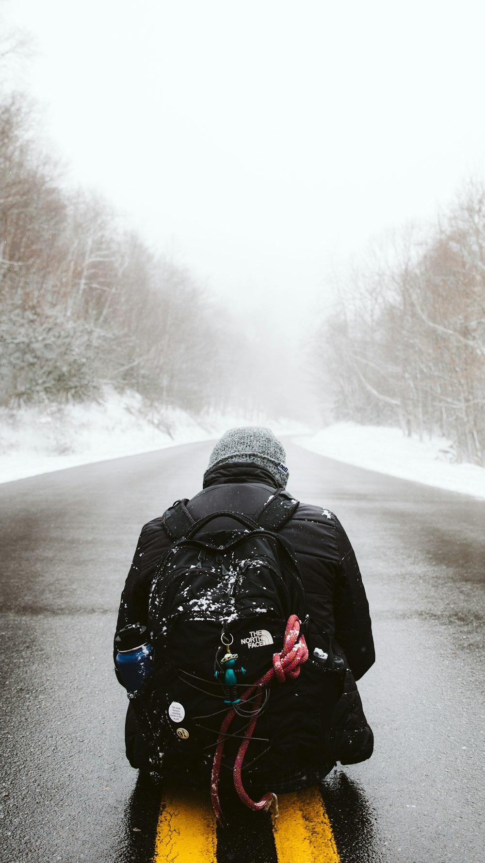 um homem andando de moto de neve por uma estrada coberta de neve