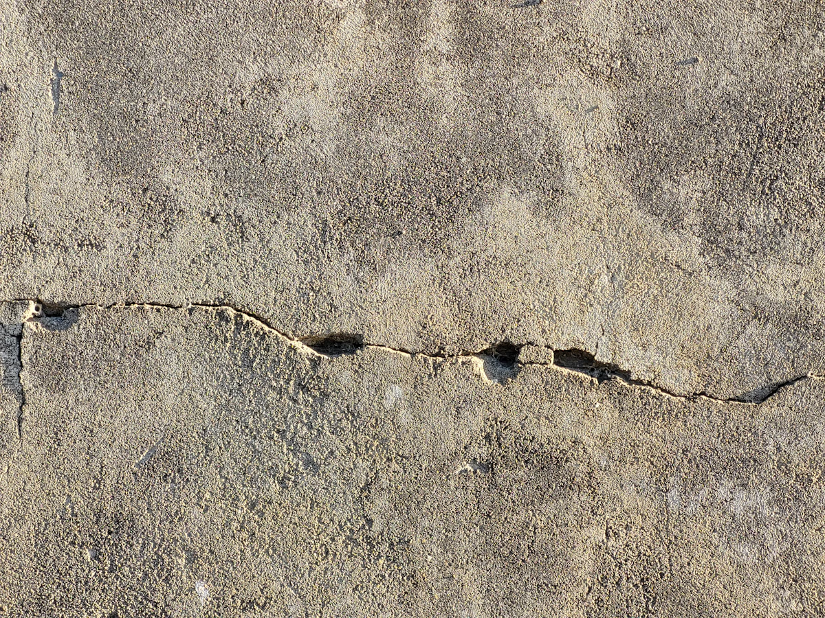 A cracked concrete slab before paver restoration