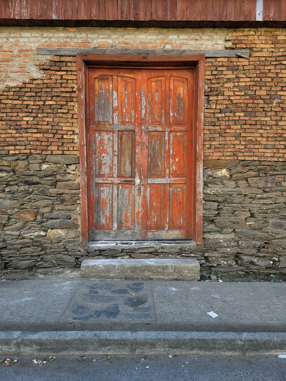 eine alte Holztür an der Seite eines Backsteingebäudes