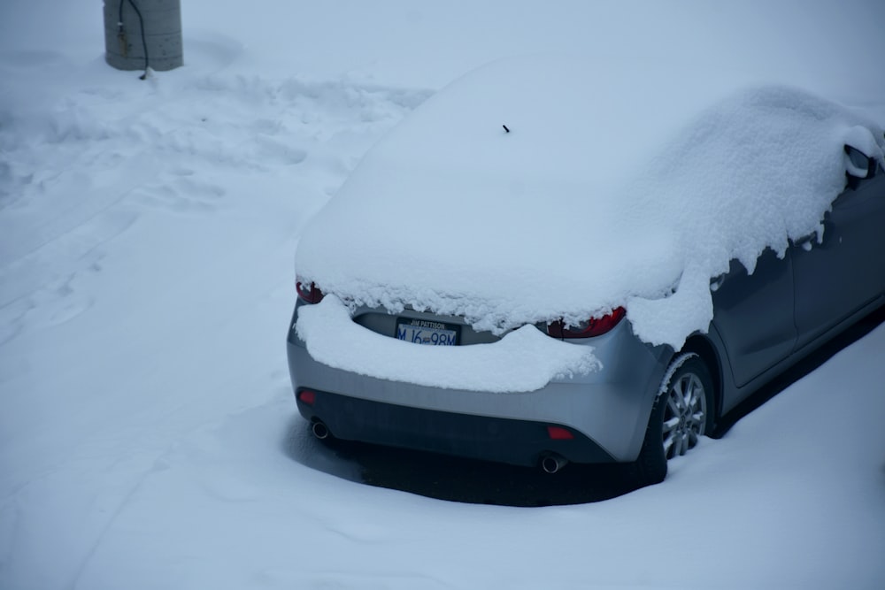 a car covered in snow parked on the side of the road