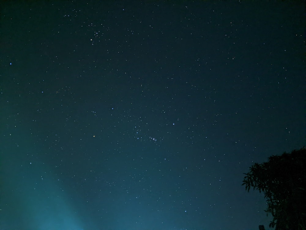 a night sky with stars and a green light